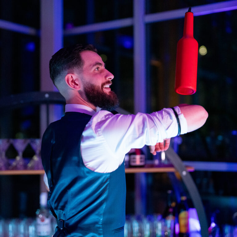 Un barman professionnel animant une soirée d'entreprise avec un bar élégant.